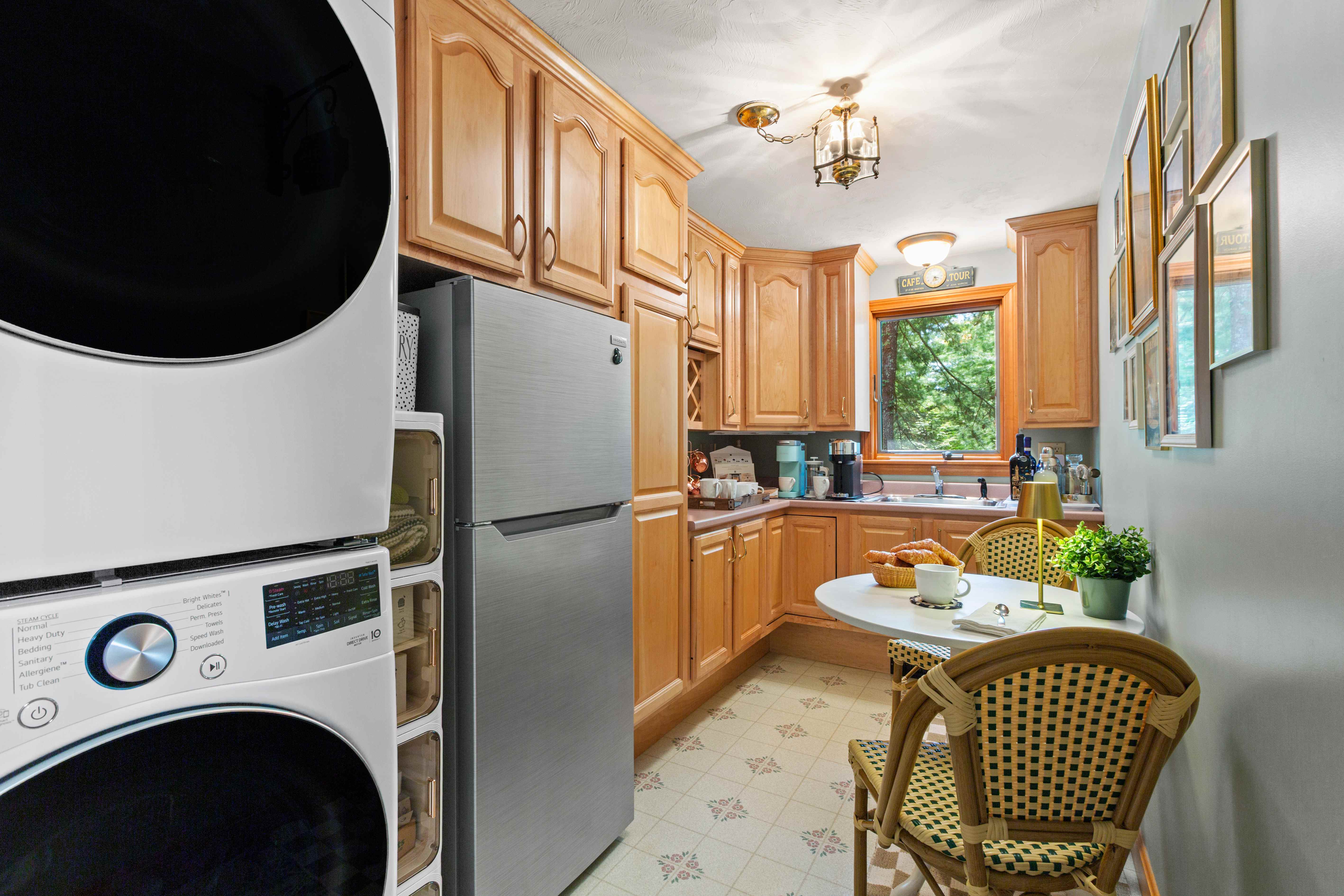Wide view from the laundry area into the Bistro Bar with refrigerator, wood cabinetry, café table, and coffee station