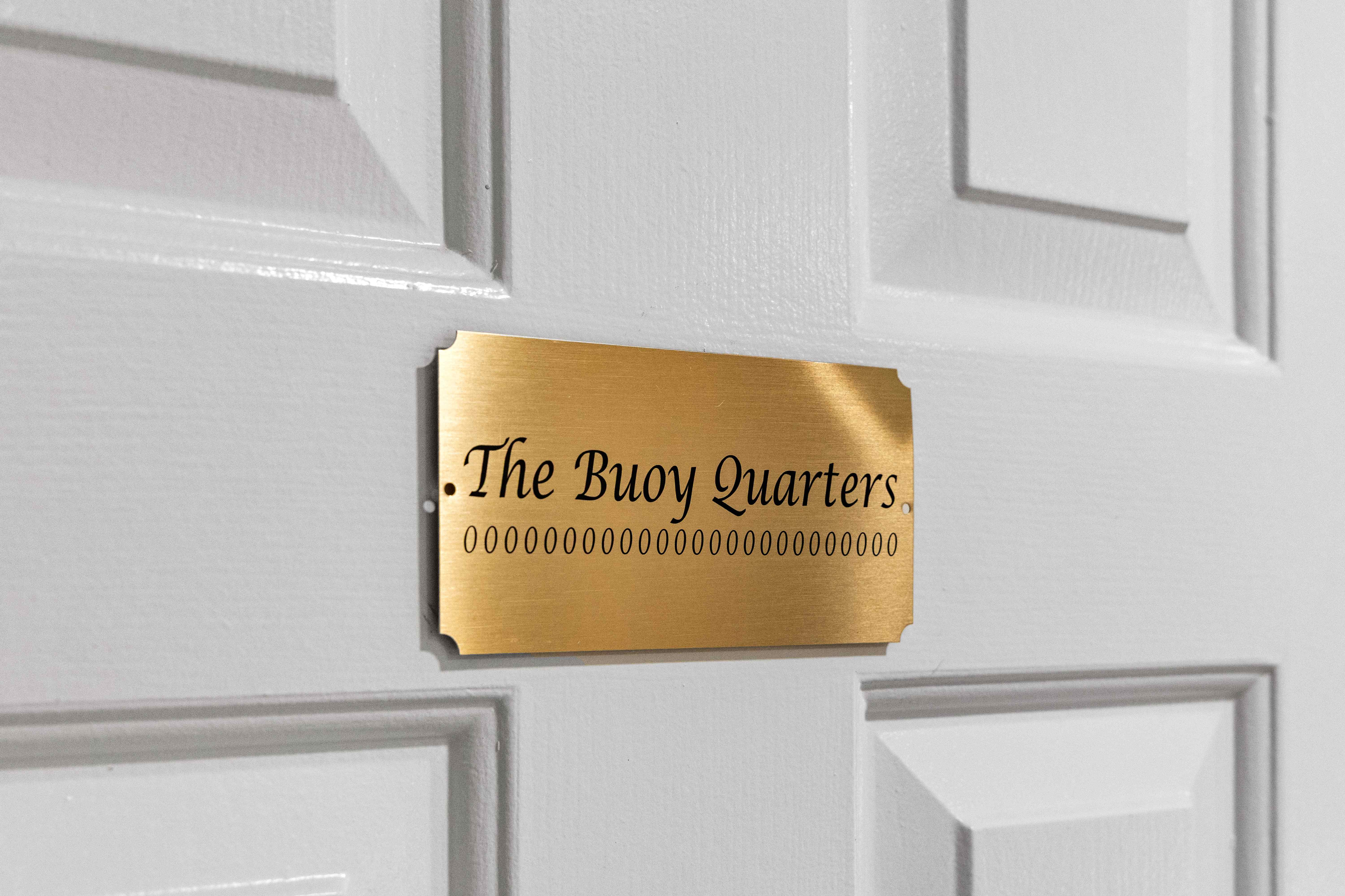 Brass door plaque engraved "The Buoy Quarters"