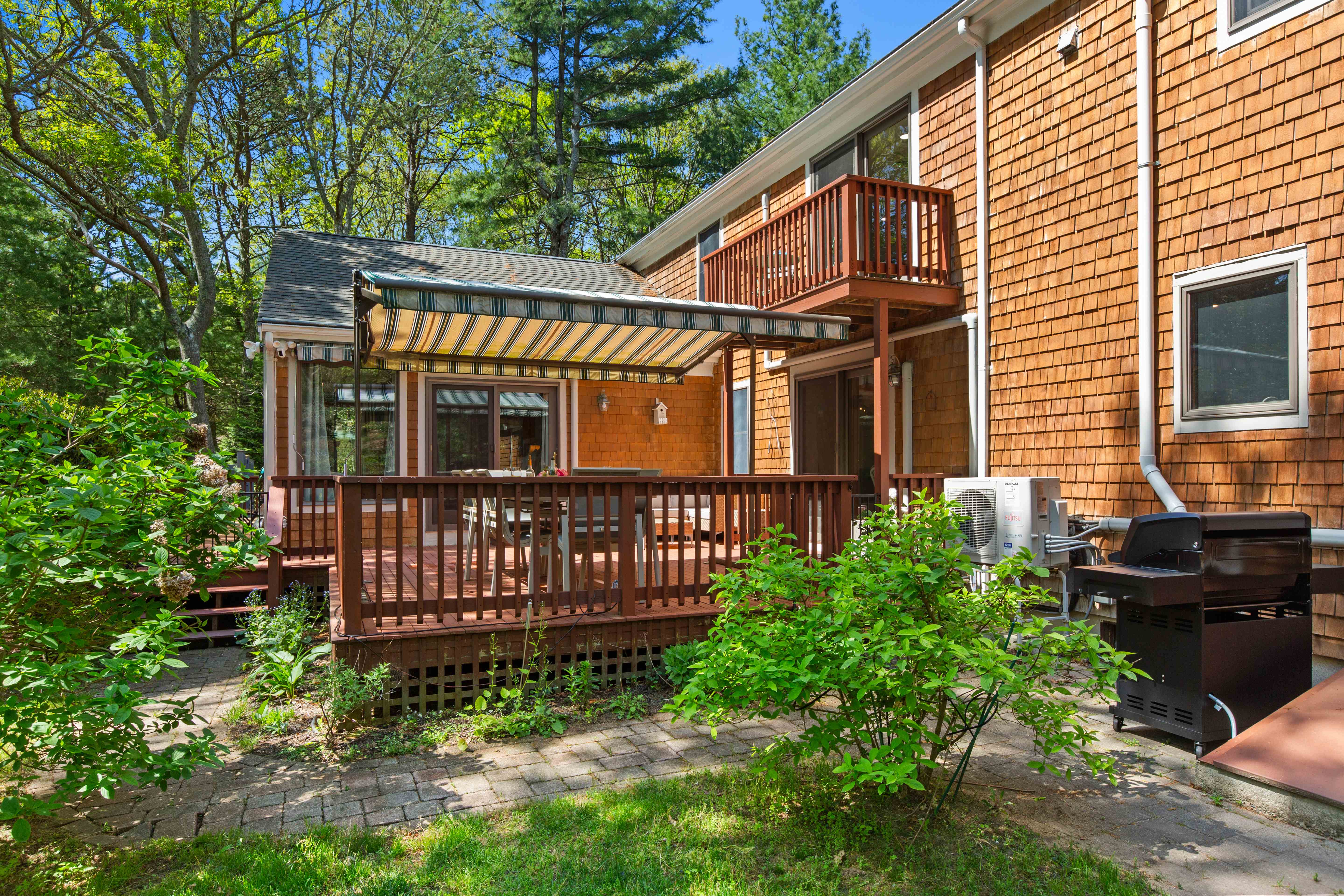 Deck dining area under the awning with the upper balcony above