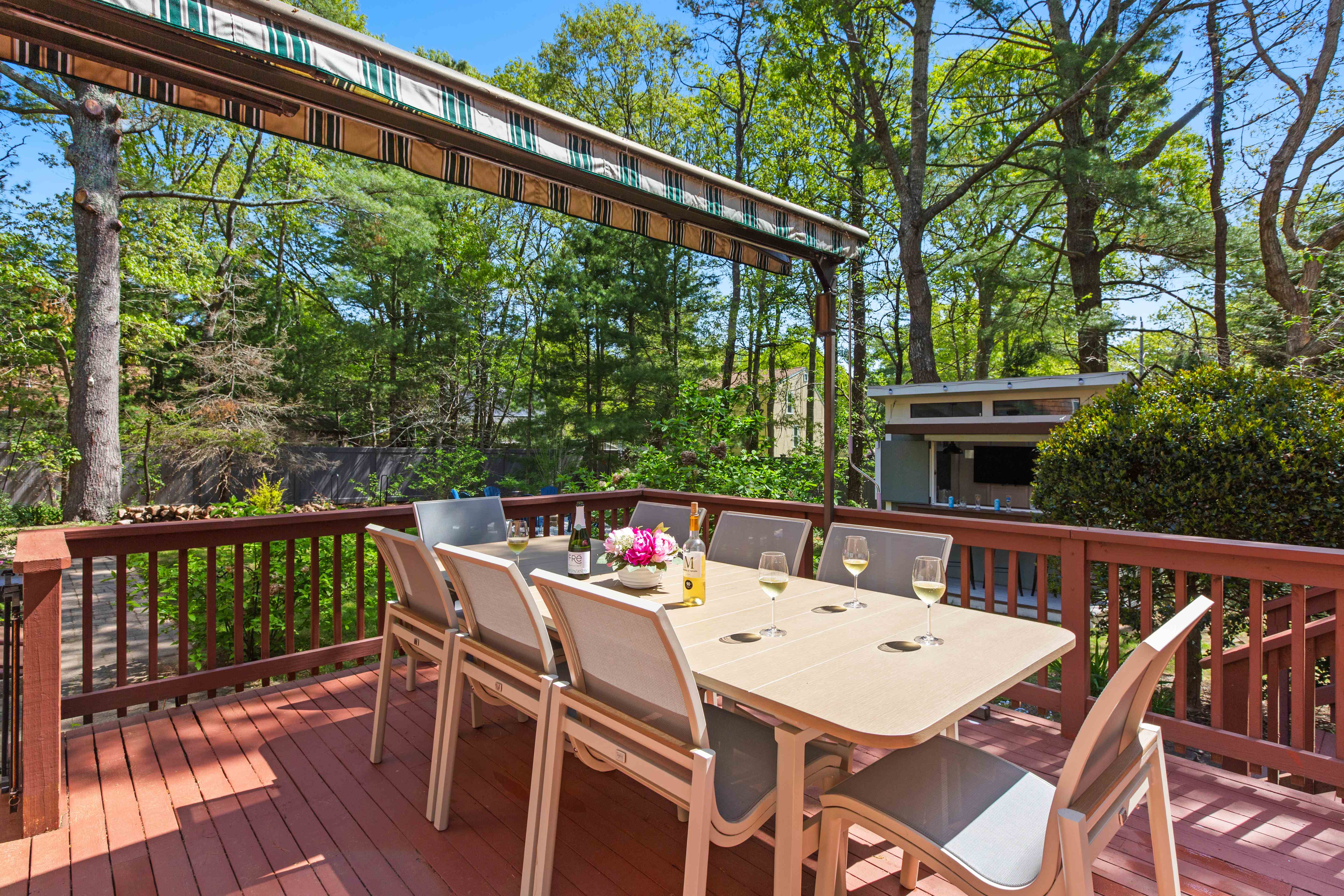 Deck seating with a clear view of the backyard bar shed and its TV