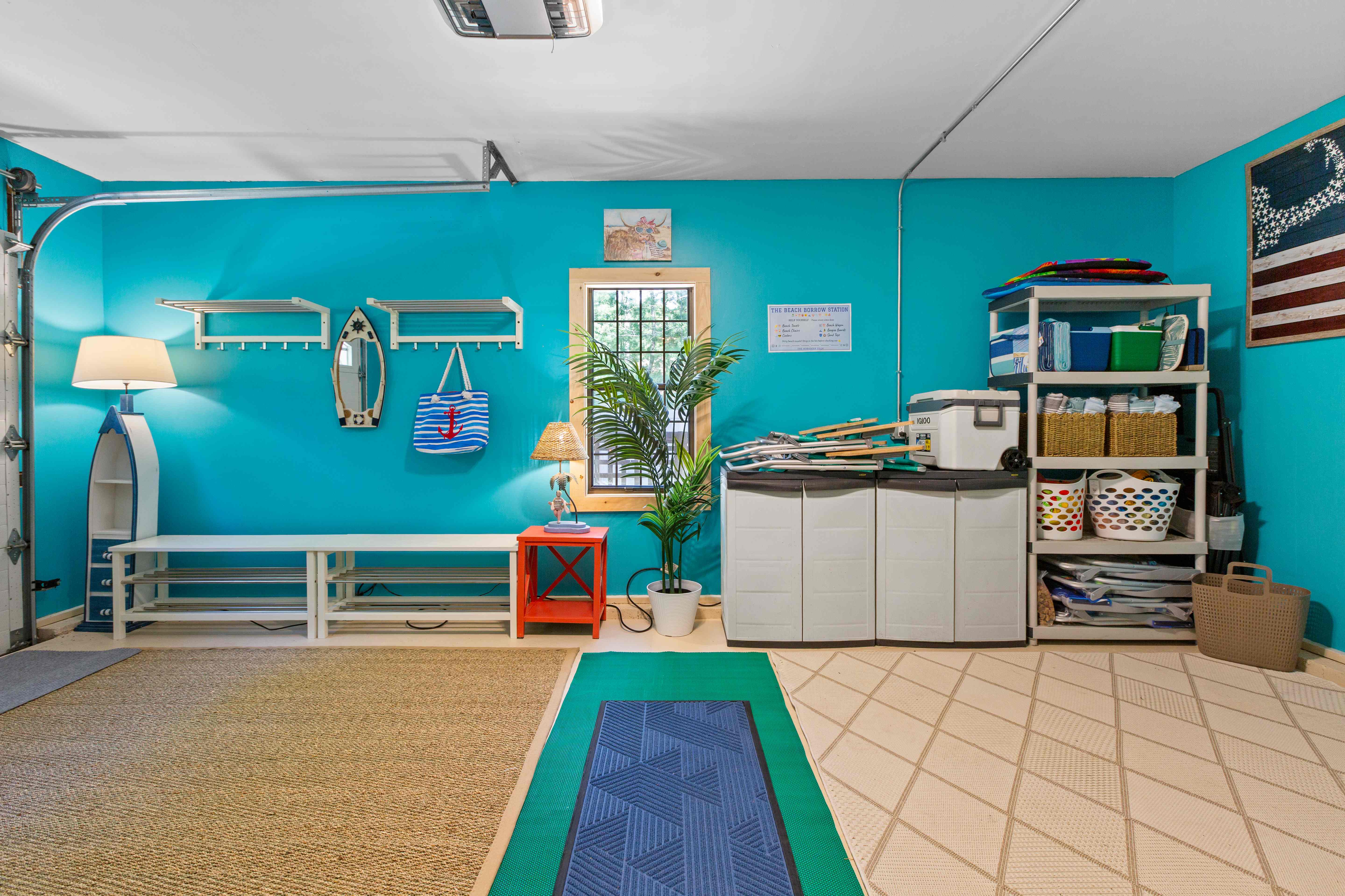 Wide view of the mudroom showing the bench, wall hooks, the Beach Borrow Station, and shelving stocked with beach gear