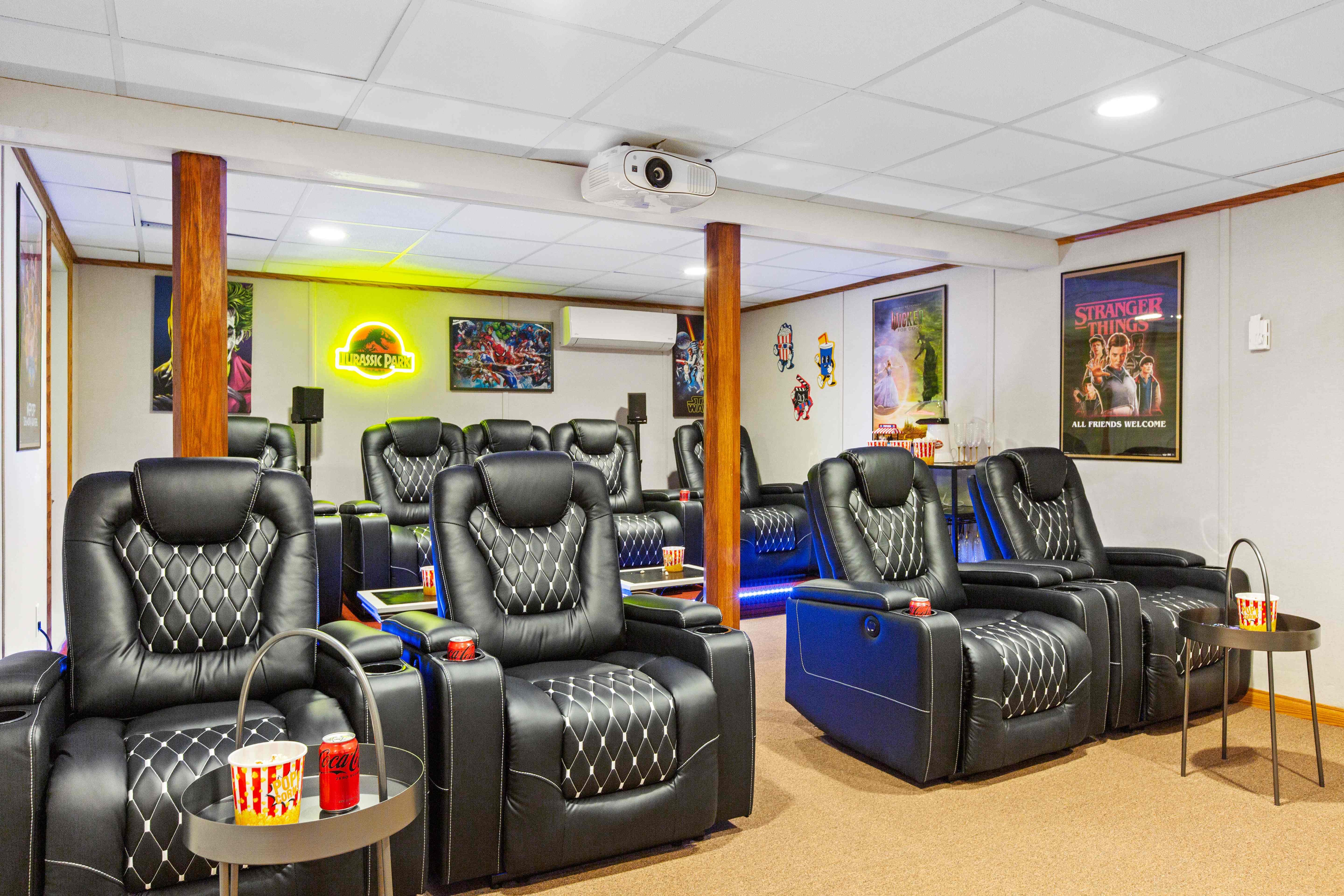 Home theater with a wall-sized screen showing JAWS, plush recliners, and cinema decor